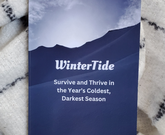 Book cover of WinterTide on top of a fuzzy white wool scarf